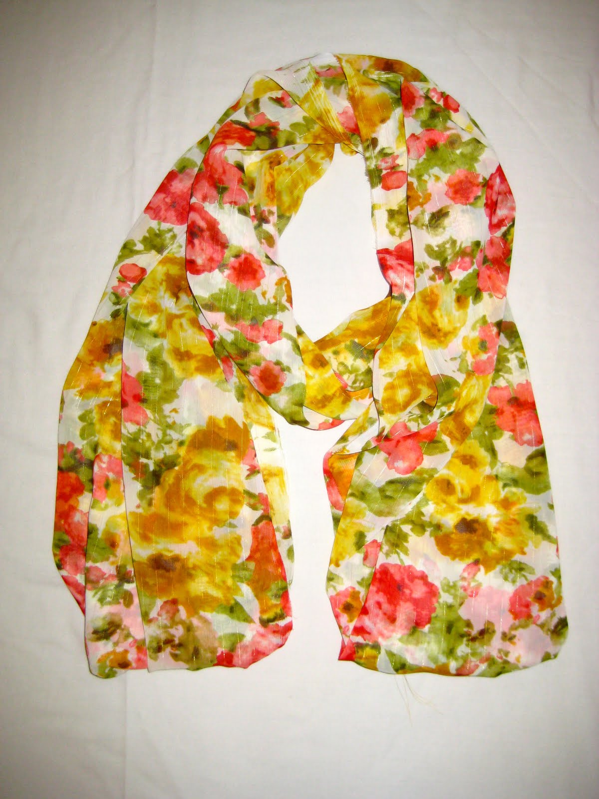 Scarf photographed flat under artificial light with flash and no model, making the fabric hard to identify