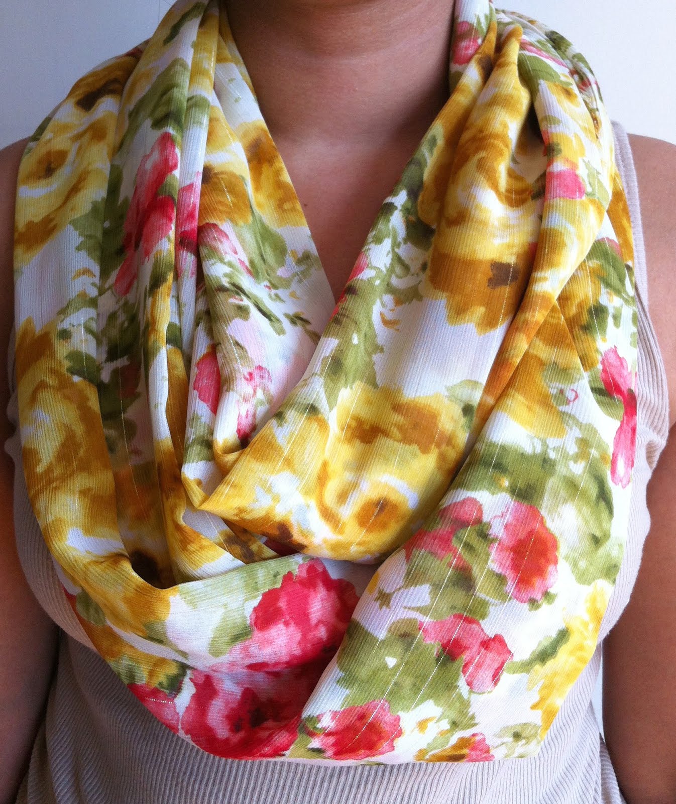 The same scarf worn by a person beside a window in natural midday light, with the material clearly visible
